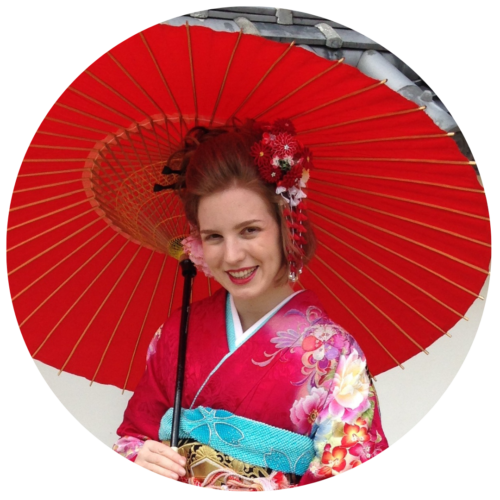 A woman in a pink kimono holding a red parasol