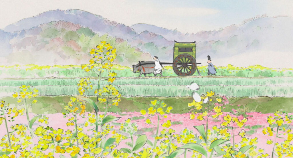 Still from The Tale of the Princess Kaguya: Two people walk alongside a wooden cart pulled by an ox through fields of yellow flowers, with mountains and trees in the background, evoking the theme of the changing seasons in Ghibli movies.